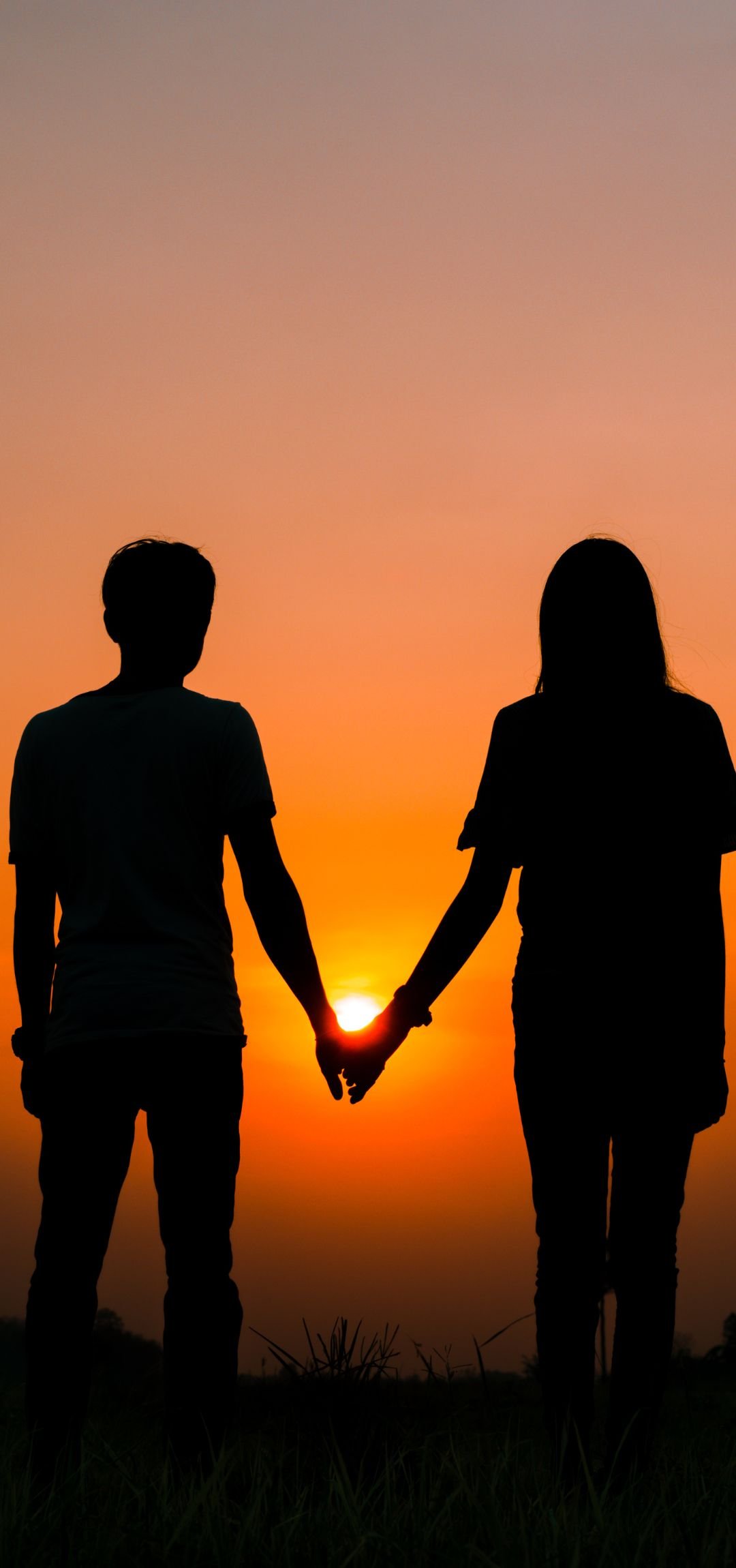 Couple holding hands at sunset, representing love and harmony, influenced by Shukra in astrology.